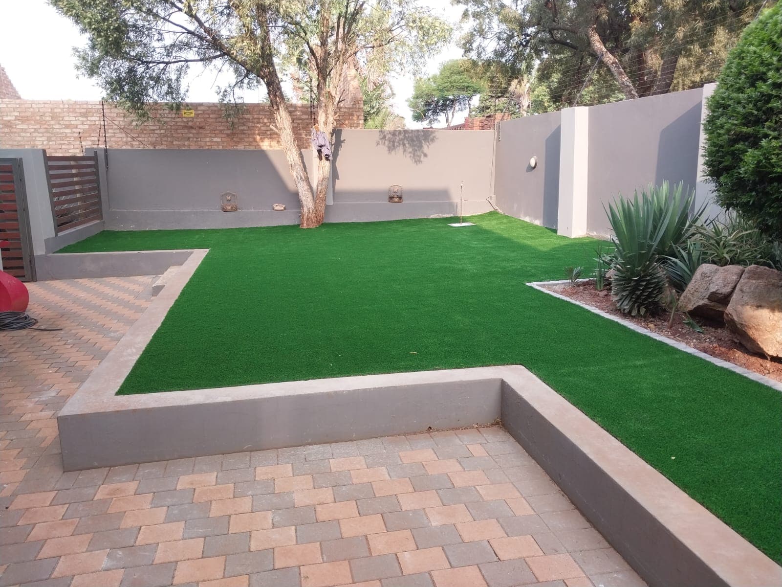Backyard transformation with artificial lawn, paving and feature garden in Tembisa